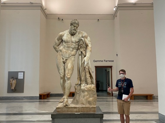 Caleb standing next to a statue