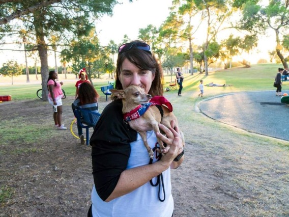 Jennifer Autz holding a small dog in a park