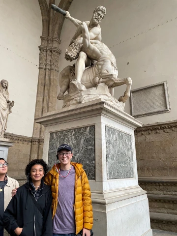 Caleb and a friend next to a sculpture